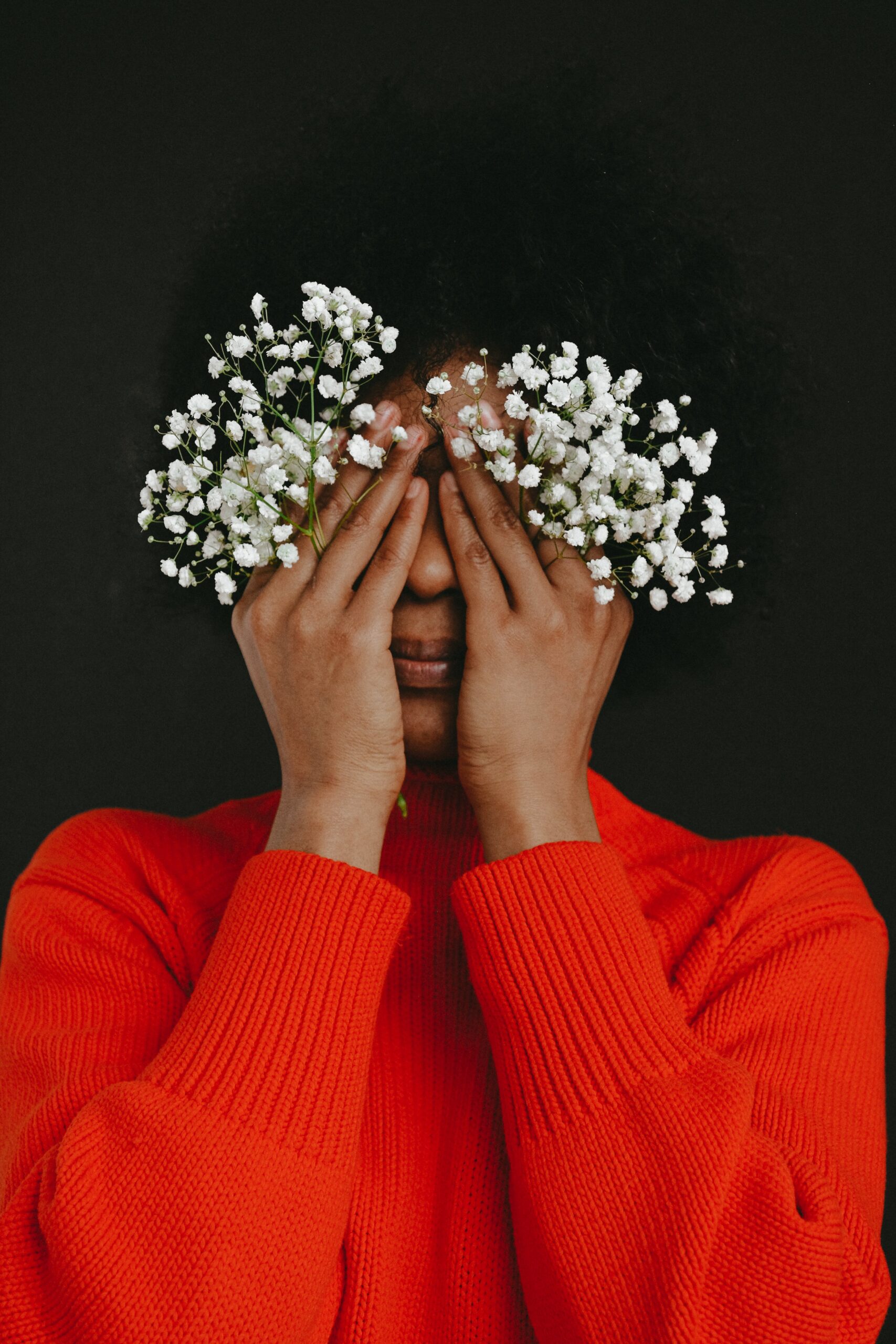 a women covering her eyes with flowers